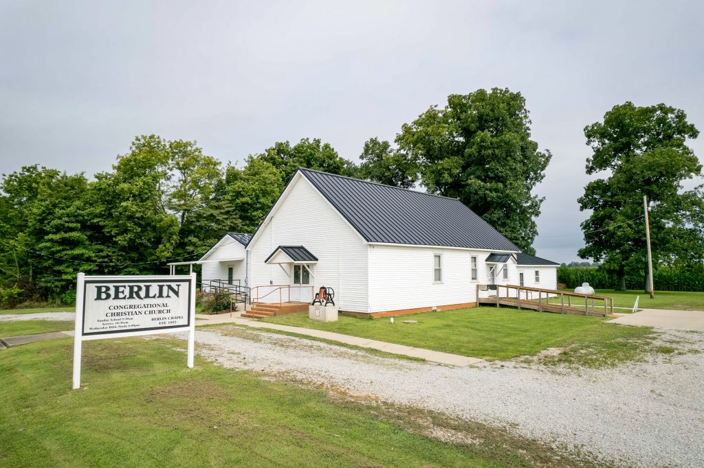 A church with a standing seam roof and a sign reading 