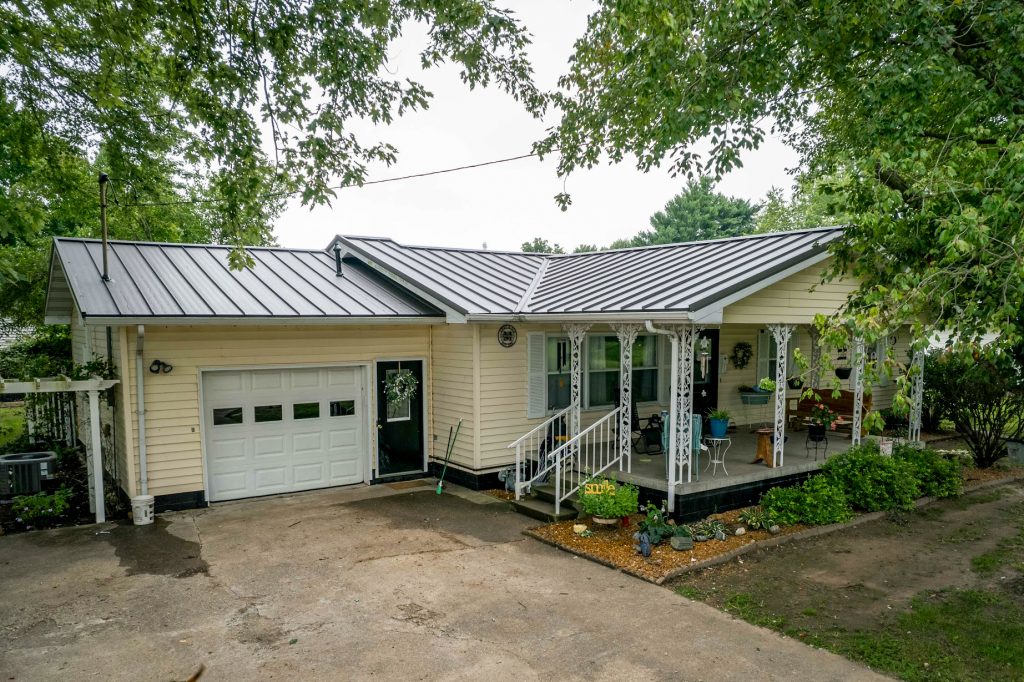 A home featuring a standing seam metal roof and an attached garage.