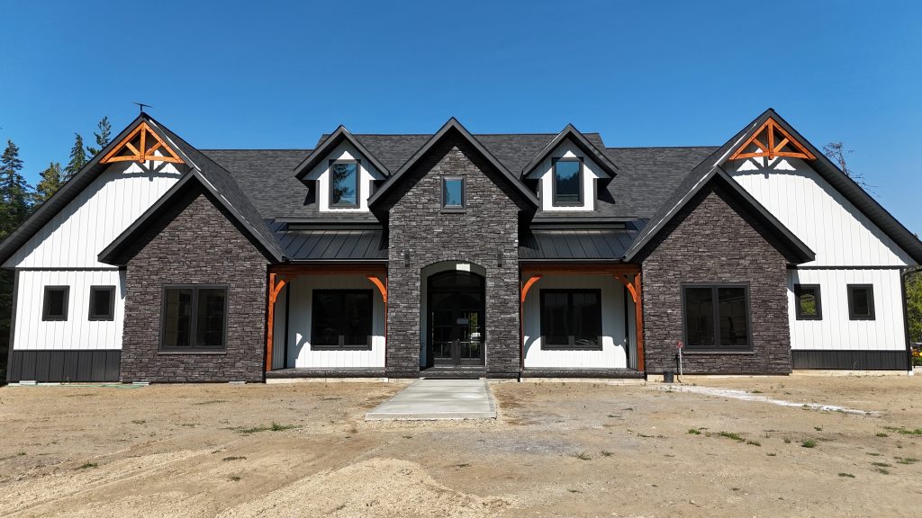 Craftsman-style home featuring Alamo White board and batten siding with stone veneer and timber bracket accents