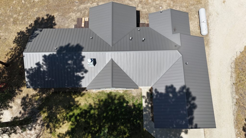 Top-down aerial view of home featuring Charcoal Crinkle standing seam metal roof system