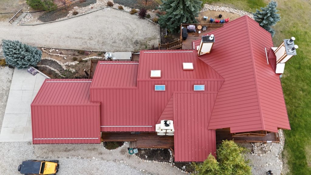 Angled aerial view of home featuring Rustic Red standing seam metal roof with skylights