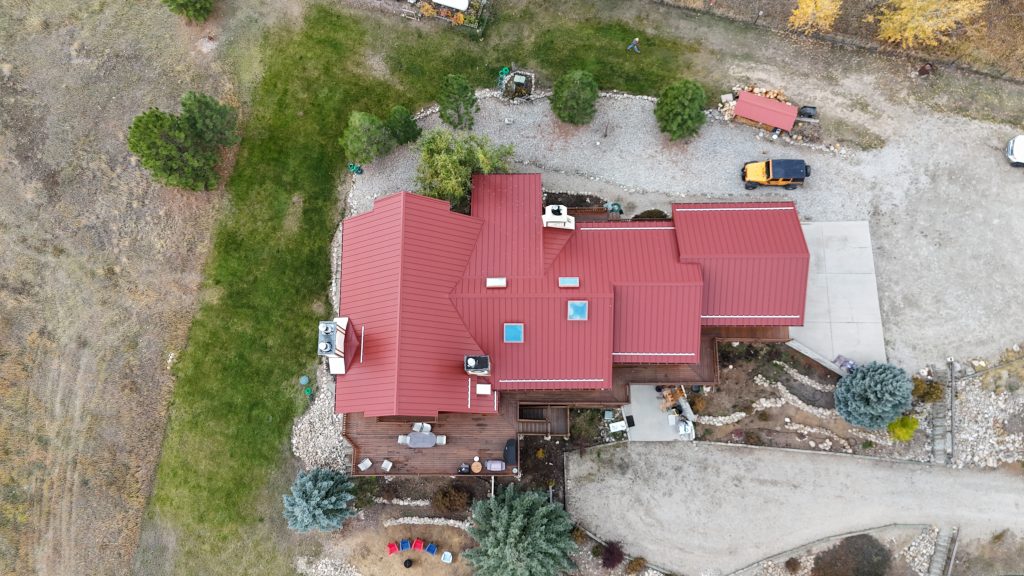 Wide overhead aerial of home with Rustic Red metal roof on rural property with landscaping