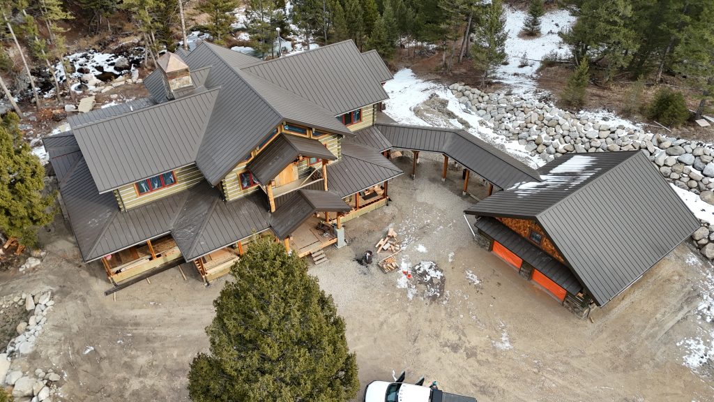 Mountain log home retreat featuring charcoal standing seam metal roof with multiple gables