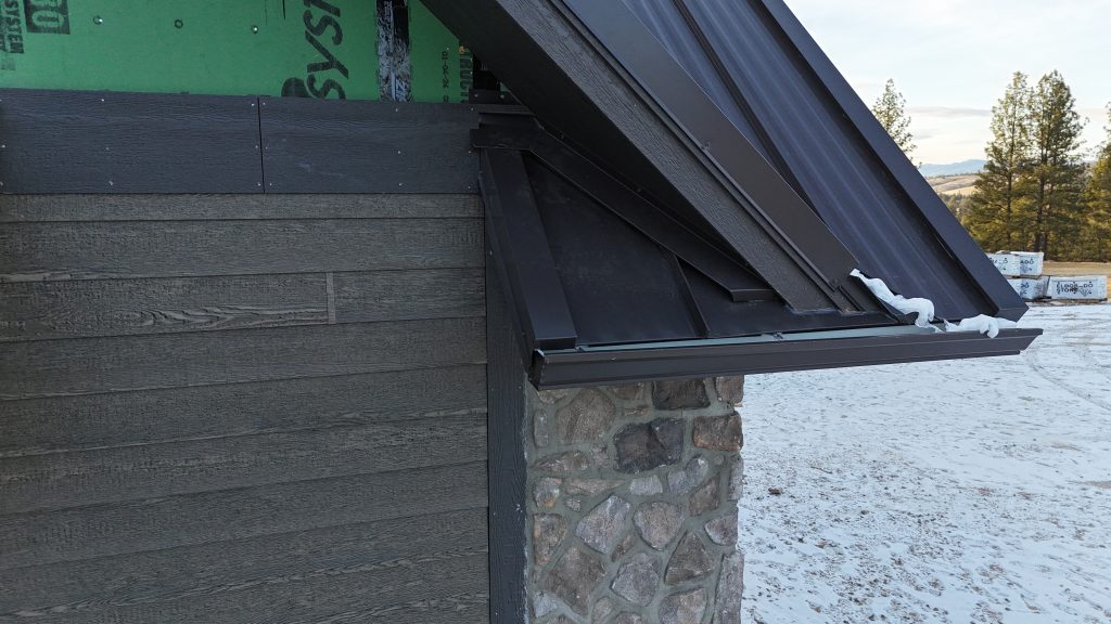 Close-up detail of standing seam metal roof edge with professional trim work and gutter installation