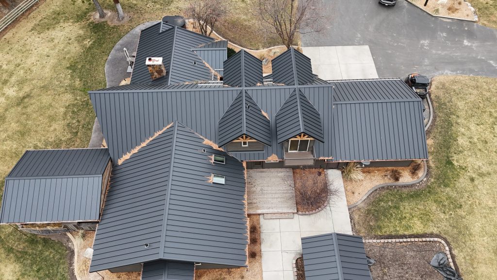 Overhead aerial of home with black standing seam metal roof system and multiple gabled sections