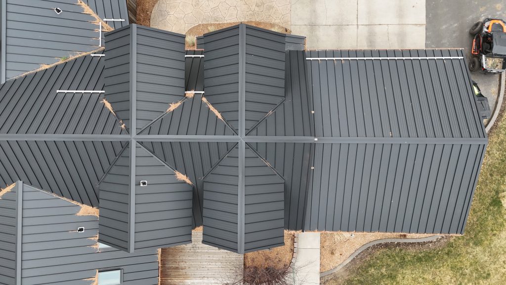 Close-up overhead detail of black standing seam metal roof showing panel installation quality