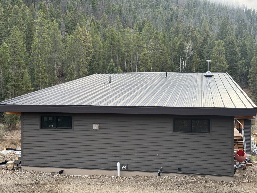 Color showcase showing matte black standing seam metal roof panel paired with burnished slate crinkle-finish metal siding panel for exterior color combination reference